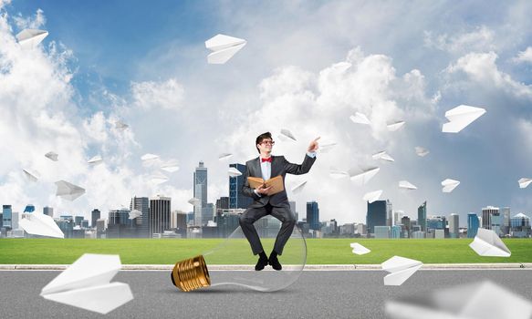 young businessman with a book. flying around paper plane in chaos