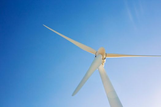 Wind turbines generating electricity with blue sky - energy conservation concept.