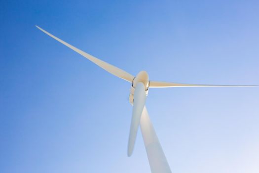 Wind turbines generating electricity with blue sky - energy conservation concept.