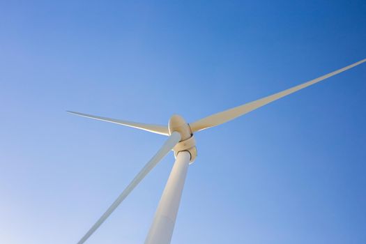 Wind turbines generating electricity with blue sky - energy conservation concept.