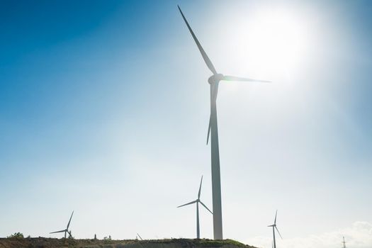 Wind turbines generating electricity with blue sky - energy conservation concept.