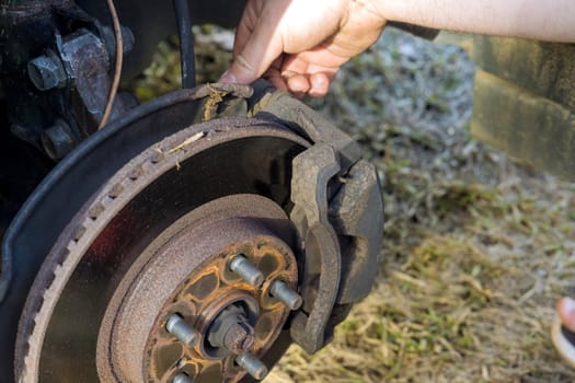 Car mechanic repair service change car disc brake pads from old brakes to new brakes