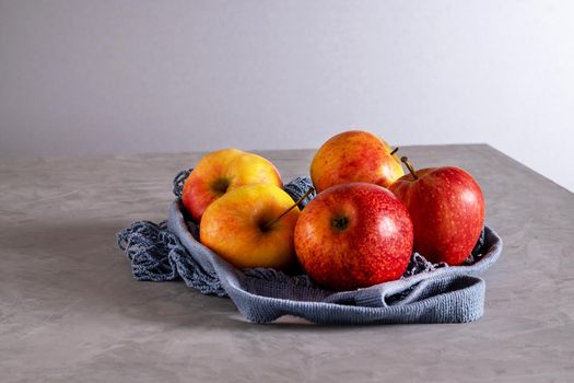 Close-up of fresh ripe juicy beautiful apples in eco-friendly reusable mesh bag made from recycled materials. Healthy food concept, vegetarianism, raw food diet, no plastic. Selective focus.