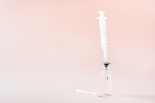 Vaccination and Immunization. Syringe needle inserted into a glass vial with vaccine