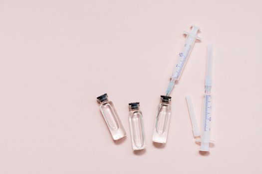 Vaccination and Immunization. Syringe needle inserted into a glass vial with vaccine. Top view