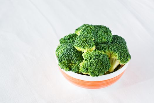 Fresh broccoli in a bowl on a table on a cloth. Diet healthy food.