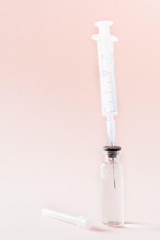 Vaccination and Immunization. Syringe needle inserted into a glass vial with vaccine. Vertical view