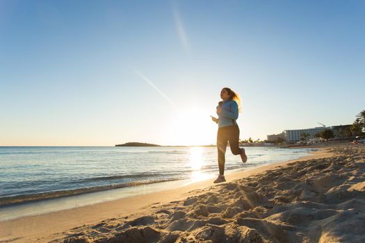 young healthy lifestyle fitness woman running at sunrise beach.