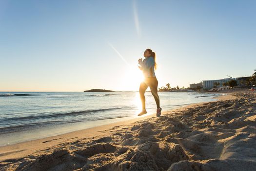 young healthy lifestyle fitness woman running at sunrise beach.