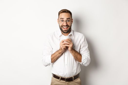 Man drinking coffee and looking excited, enjoying drink, standing over white background.