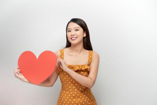 young asian woman holding a red heart shape