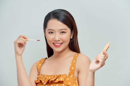 Pretty woman applying makeup, lifestyle portrait