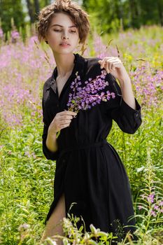 A woman holds a bouquet of lupines in her hand. Soft focus.