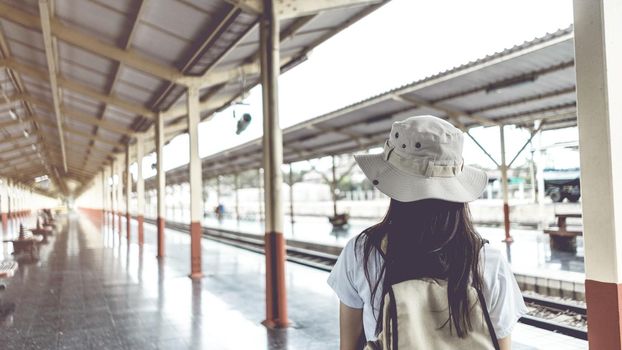Banner Vintage style. Young female tourists with backpacks waiting for the train to travel at the train station. Travel and vacation concept