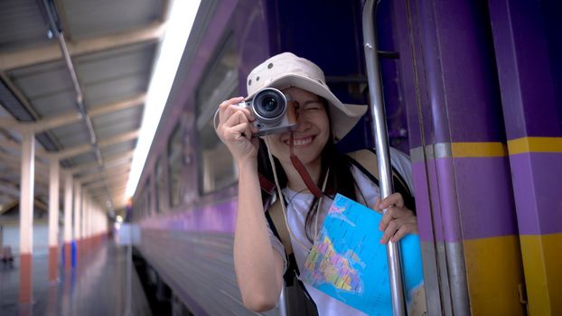 Young girl tourists smile and use camera take a photo travel photography on the train while waiting for the train to travel. Freedom active lifestyle concept.