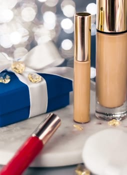 Cosmetic branding, Christmas glitter and girly blog concept - Holiday make-up foundation base, concealer and blue gift box, luxury cosmetics present and blank label products for beauty brand design