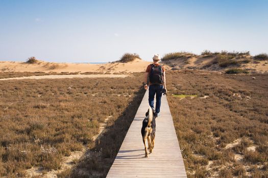 Outdoors lifestyle image of travelling man with cute dog. Tourism concept