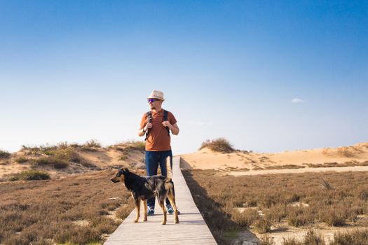 Outdoors lifestyle image of travelling man with cute dog. Tourism concept