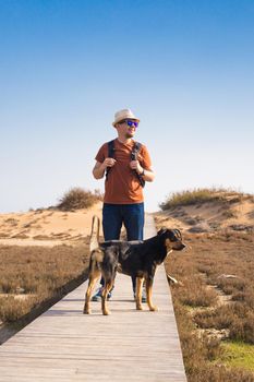 Outdoors lifestyle image of travelling man with cute dog. Tourism concept