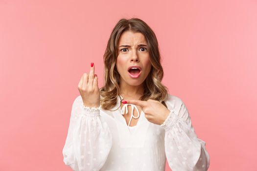 Close-up portrait of shocked and upset, displeased blond girl complaining friend on boyfriend didnt made proposal, pointing at finger without wedding ring, want get married.