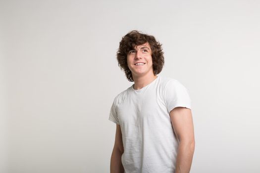 Young white handsome men smiling in white t-shirt in studio