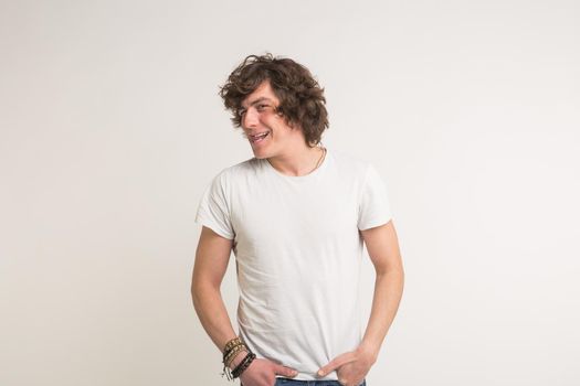 Young white handsome men smiling in white t-shirt in studio