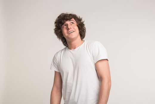 Young white handsome men smiling in white t-shirt in studio