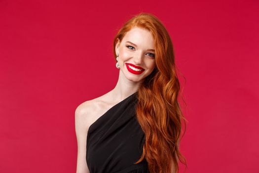 Makeup, beauty and women concept. Close-up of elegant pretty redhead woman in luxurious slim black dress, red lipstick, smiling cheerful and pleased, attend formal event, party or romantic date.