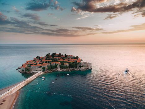 Sveti Stefan Island in the light of the pink sunset rays of the sun. Montenegro. High quality photo