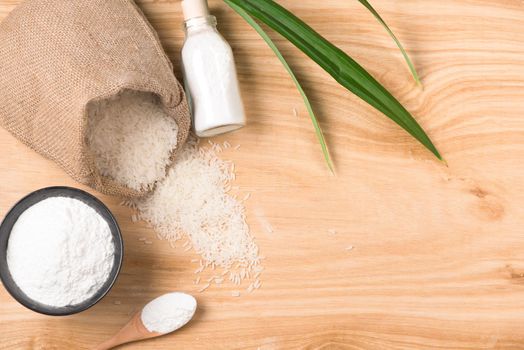 rice flour in a wooden bowl, rice on the wooden background. gluten-free