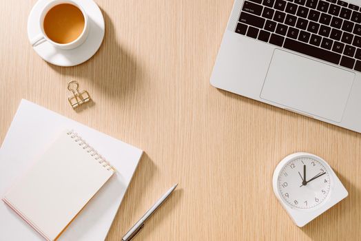 Office desk table with laptop, smart phone, cup of coffee, pen, pencil and notebook. Office supplies and gadgets on desk table. Working desk table concept.