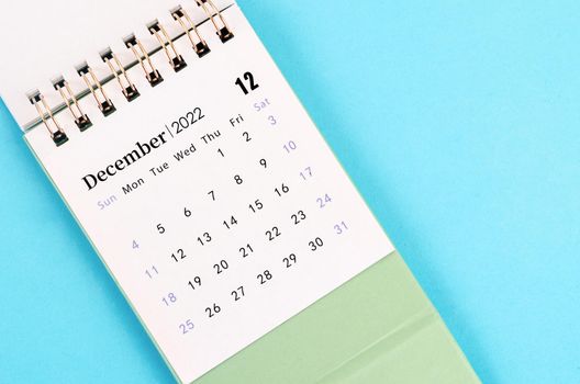 The mini December 2022 desk calendar on blue background.