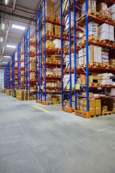 Huge distribution warehouse with high shelves and loaders