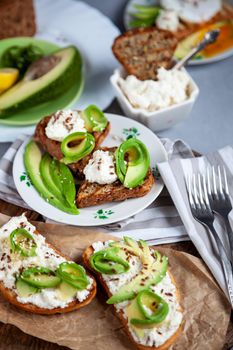 Sandwiches with soft cheese, avocado and cucumber. Breakfast is on the table. Healthy food. Toast and spread on it. Avocado sandwich stilllife. Healthy food.