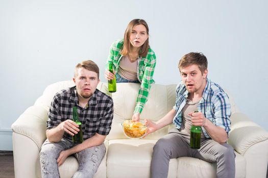 Young men drink beer, eat pizza and cheering for football