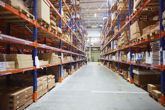 Huge distribution warehouse with high shelves and loaders