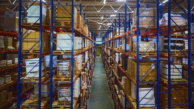 Huge distribution warehouse with high shelves and loaders