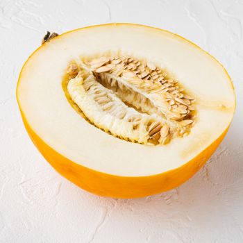 Sugar melon cut in half set, on white stone table background, square format