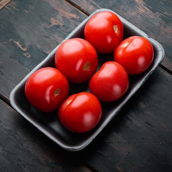 Red ripe tomatoes, on dark wooden background