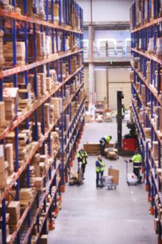 Blur warehouse background. Warehouse worker taking package in the shelf in a large warehouse in a large warehouse.