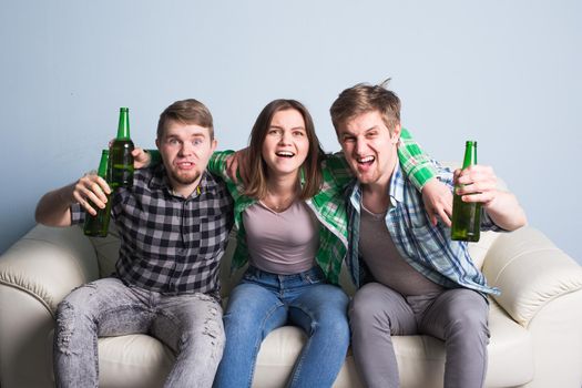 Happy friends or football fans watching soccer on tv and celebrating victory at home.Friendship, sports and entertainment concept.