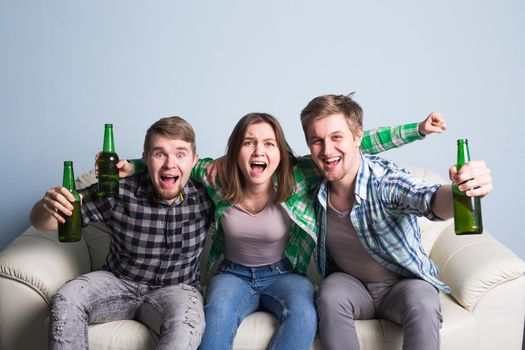 Happy friends or football fans watching soccer on tv and celebrating victory at home.Friendship, sports and entertainment concept.