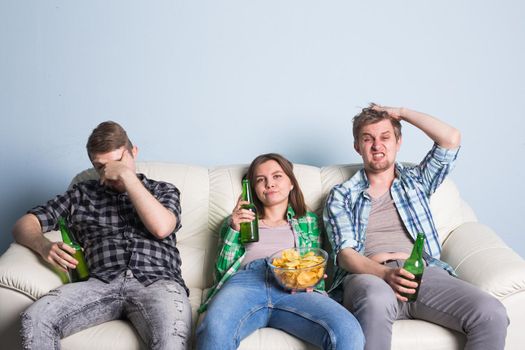 Sad friends or football fans watching soccer on tv. Losing a favorite team.