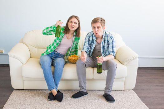 Sad friends or football fans watching soccer on tv. Losing a favorite team.