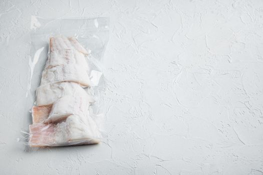 Raw haddock fish skinless plastic vacuum packaged, on white background with copy space for text