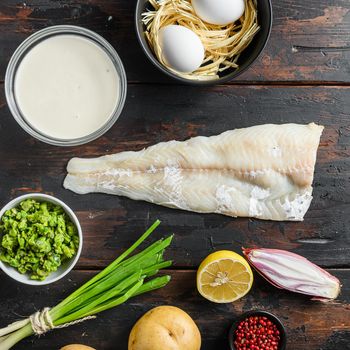 Organic fish and chips ingredients white fish fillet beer batter, potatoe, tartar sauce, minty mushy peas, lemon , shallot, mint, garlic, salt, peppercorns on rustic old wood table top view square crop.