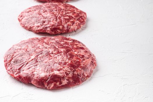 Patty of minced meat for burger set, on white stone background