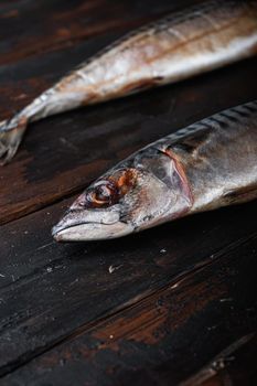 Two mackerel on wooden table with space for text.