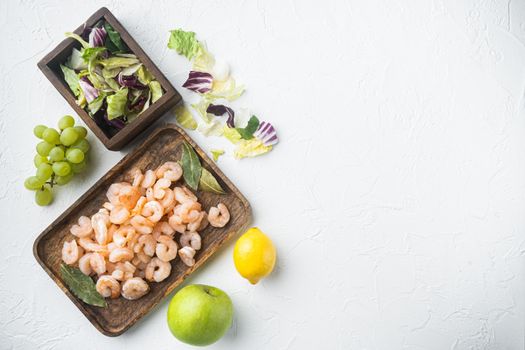 Healthy lifestyle - cooking of fresh salad of prawn, green salad, olive set, with sauce apple and grape, on white stone background, top view flat lay, with copy space for text