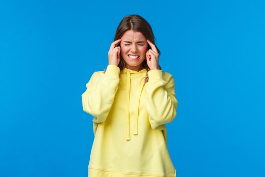 Girl trying to focus during exams, feel unwell. Troubled uneasy young blond woman massaging temples with closed eyes and grimace from painful feeling, suffer headache or migraine.